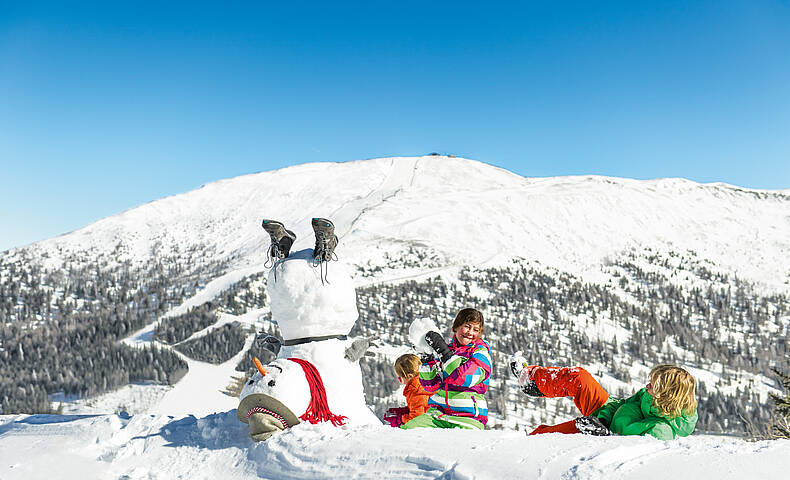 Katschberg_Kinder haben Spaß im Schnee mit Schneemann 